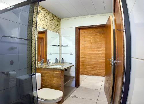 a bathroom with a toilet and a sink at Moradas do Campeche CSABC in Florianópolis