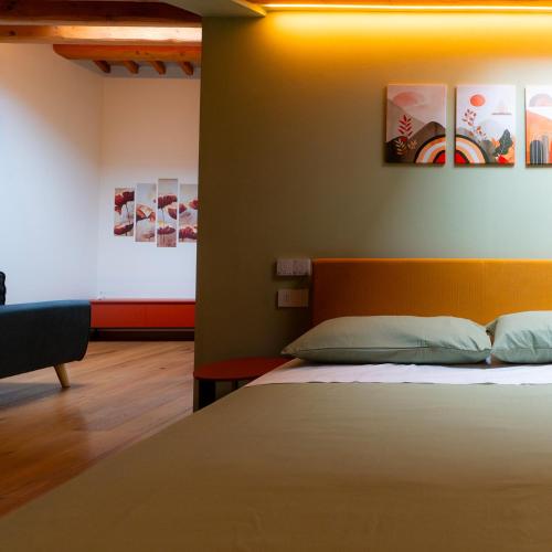 a bedroom with a bed and paintings on the wall at Antica Corte Lugo in Lugo