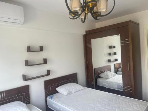 une chambre avec deux lits et un miroir dans l'établissement 1 Bedroom Ground in Marassi Marina 1, à El Alamein