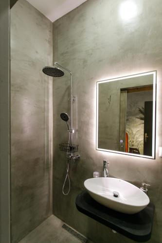 a bathroom with a sink and a shower with a mirror at SA Studio 24 in Tirana