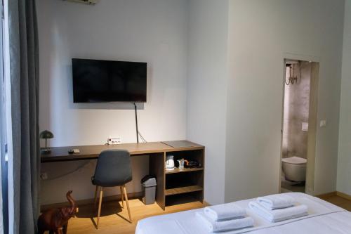 a bedroom with a desk with a television and a chair at SA Studio 24 in Tirana