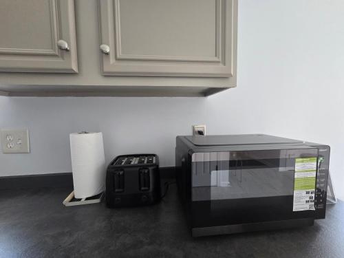 a microwave sitting on a kitchen counter next to a roll of paper towels at Luxury affordable Room in Quite area in Atlanta in Atlanta