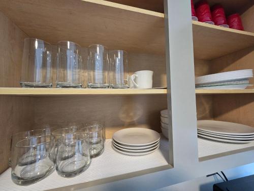 a cupboard filled with glasses and plates and bowls at Luxury affordable Room in Quite area in Atlanta in Atlanta