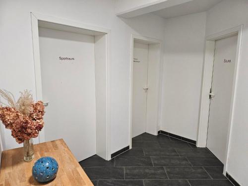 a room with white walls and a vase on a table at Ferienappartement-Abendsonne-3 in Mirow
