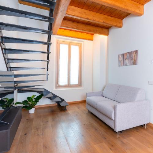 a living room with a couch and a spiral staircase at Antica Corte Lugo in Lugo