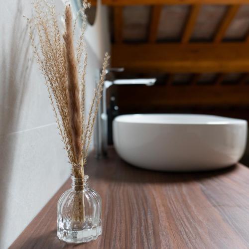 a glass vase on a wooden table with a bowl at Antica Corte Lugo in Lugo