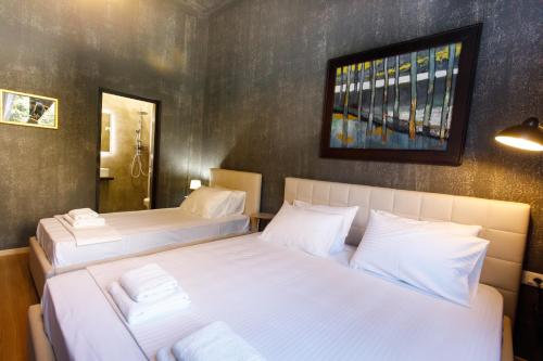 two beds in a room with white sheets at SA Studio 24 in Tirana