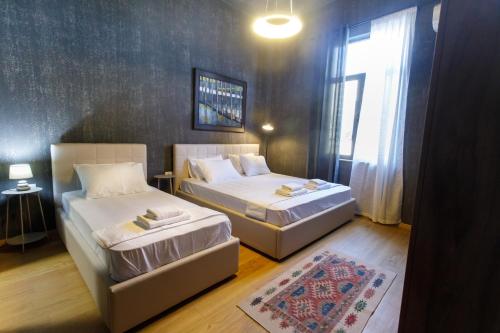 two beds in a small room with a window at SA Studio 24 in Tirana