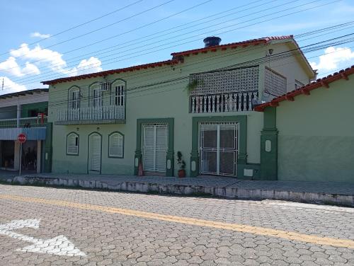 a green and white building on the side of a street at hospedagem casa da waldir, quarto suíte 01 in Goiás