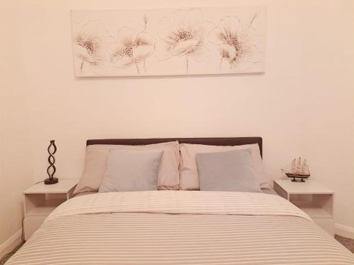 a bedroom with a bed with a painting on the wall at Cozy 2BR Home Leeds Free Parking & Wifi Pets Welcome in Belle Isle