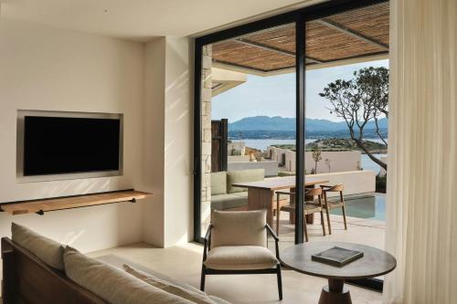 a living room with a tv and a couch and a table at JW Marriott Crete Resort & Spa in Marathi