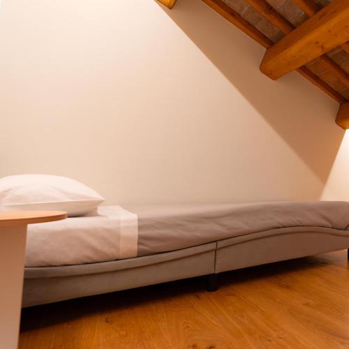 a bed in the corner of a room with a table at Antica Corte Lugo in Lugo