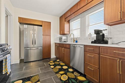 a kitchen with wooden cabinets and a stainless steel refrigerator at The Gilded Cottage Entire Home in Rockford