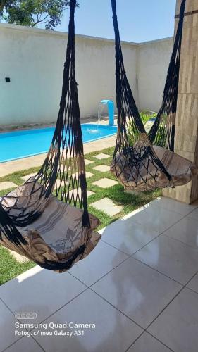 two hammocks sitting next to a swimming pool at Francisco das Chagas Andrade in Martins