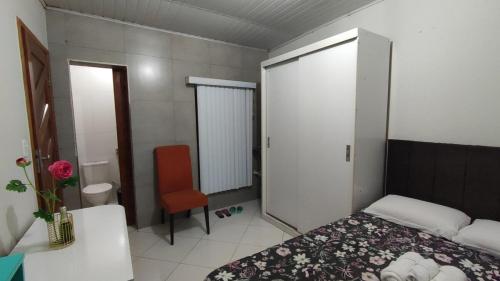 a small bedroom with a bed and a chair at Apê 03 - confortável e perto de tudo in Vitória da Conquista