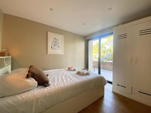 une chambre avec un lit avec deux animaux en peluche dessus dans l'établissement Villa de prestige au Pyla-Vue mer, à La Teste-de-Buch