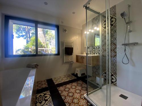 une salle de bain avec une douche et un lavabo et une fenêtre dans l'établissement Villa de prestige au Pyla-Vue mer, à La Teste-de-Buch