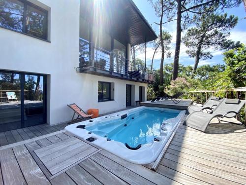 une piscine sur une terrasse à côté d'une maison dans l'établissement Villa de prestige au Pyla-Vue mer, à La Teste-de-Buch