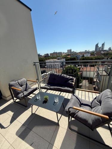 a patio with two chairs and a table on a balcony at Jesolo attic - beach spot in Lido di Jesolo