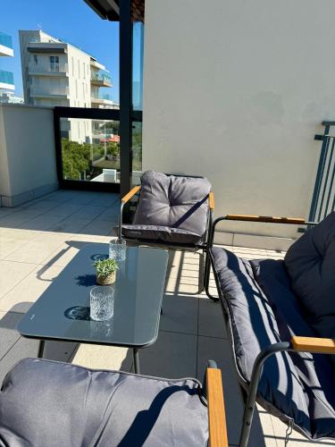 a patio with a table and chairs on a balcony at Jesolo attic - beach spot in Lido di Jesolo