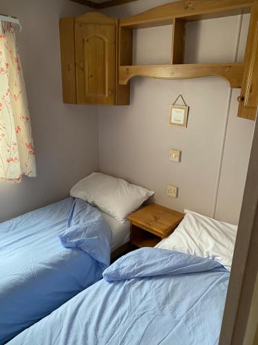 two beds in a small room with a bunk bed at Lovely 2 bedroomed Caravan on Edwards Towyn in Kinmel Bay