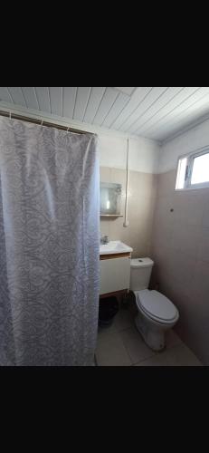 a bathroom with a toilet and a shower curtain at Apartment in an excellent location in Colonia del Sacramento
