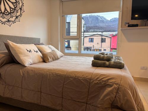 Un dormitorio con una cama grande con una ventana grande. en Departamento Austral II, en Ushuaia