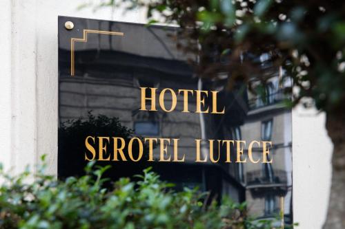 a hotel sign on the side of a building at Hôtel Serotel Lutèce in Paris