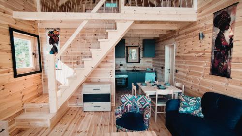 una sala de estar con una escalera en una cabaña de madera en Above the Lake, en Rogani