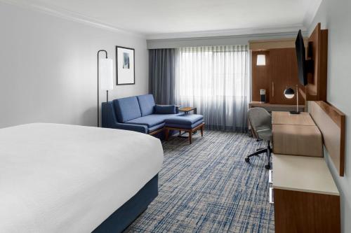 a hotel room with a bed and a blue chair at Courtyard Palo Alto Los Altos in Palo Alto