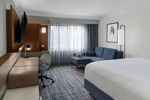 a hotel room with a bed and a desk and a couch at Courtyard Palo Alto Los Altos in Palo Alto