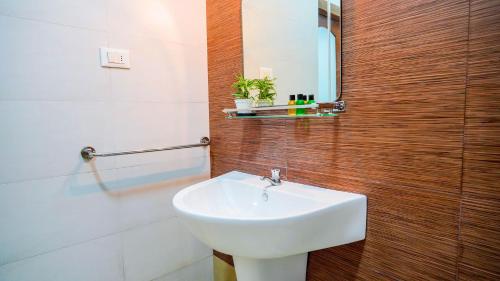 a bathroom with a white sink and a mirror at Serene Villa Airport Transit in Katunayake
