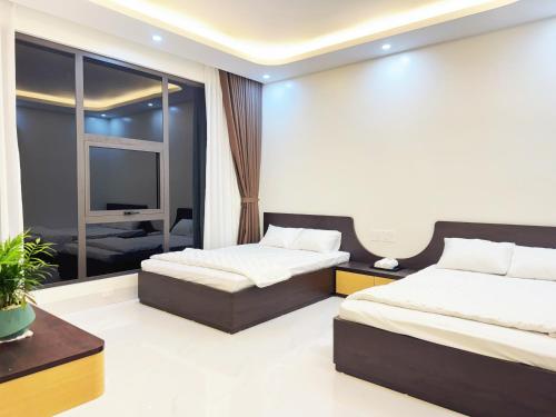 a bedroom with two beds and a tv at Mai Linh Hotel in Ðồng Lạc