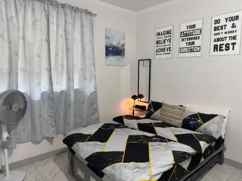 una camera con un letto bianco e nero e una finestra di Panchitos Nest a Morong