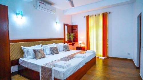 a bedroom with a large bed in a room at Serene Villa Airport Transit in Katunayake