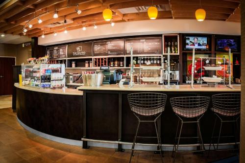 a bar with bar stools in a restaurant at Courtyard by Marriott Norman in Norman