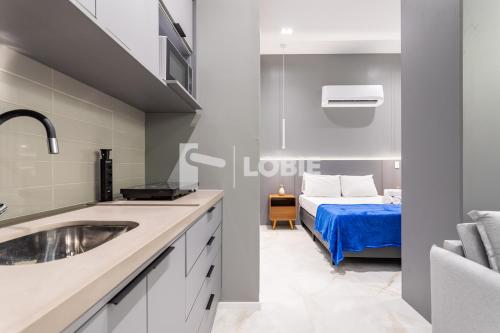 a bathroom with a sink and a bed in a room at Lobie Dias Downtown in Rio de Janeiro