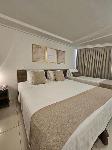 two beds in a hotel room with two beds at FLAT BLUE SUNSET in João Pessoa