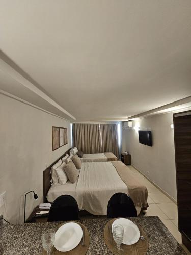 a bedroom with a large bed with two tables at FLAT BLUE SUNSET in João Pessoa