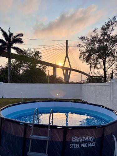 a hot tub with a chair in front of a bridge at Confort room in Mata Redonda