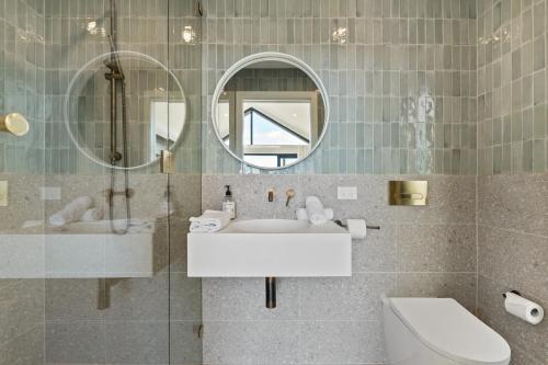a bathroom with a sink and a mirror and a toilet at Mi Casa Su Casa - Brand New Home In Moss Vale in Moss Vale