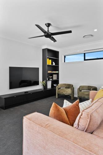 a living room with a couch and a ceiling fan at Mi Casa Su Casa - Brand New Home In Moss Vale in Moss Vale