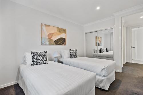 a white room with two beds and a mirror at Mi Casa Su Casa - Brand New Home In Moss Vale in Moss Vale