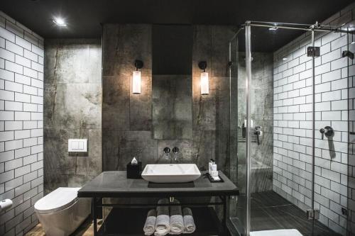 a bathroom with a sink and a shower at Century City Hotel Urban Square in Cape Town