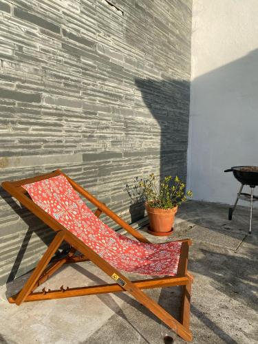 a red chair sitting next to a brick wall at Pinho Azul - Beach House in Apúlia