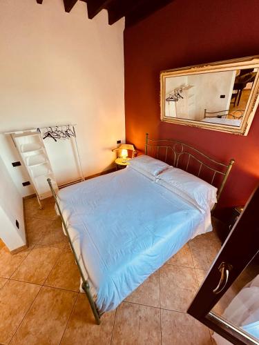 a bedroom with a bed with a mirror and a mirror at Valdorcia Belvedere b&b in Pienza