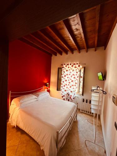 a bedroom with a large bed with a red wall at Valdorcia Belvedere b&b in Pienza