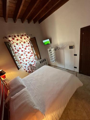 a bedroom with a large white bed and a window at Valdorcia Belvedere b&b in Pienza