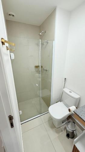 a white bathroom with a shower and a toilet at ZYZ Retratíl, Ar condicionado, Piscina e Estacionamento incluÍdo in Sao Paulo