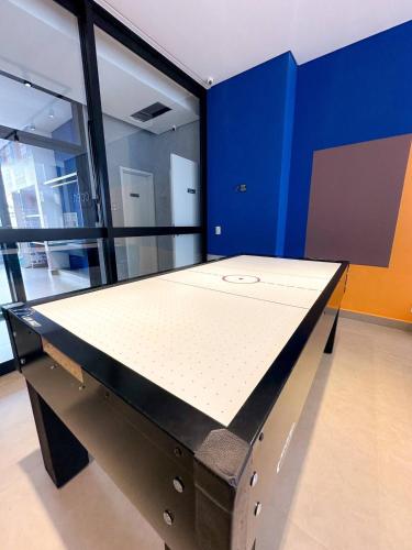 a large ping pong table in a room with blue walls at ZYZ Retratíl, Ar condicionado, Piscina e Estacionamento incluÍdo in Sao Paulo